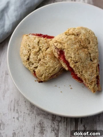 Two strawberry rhubarb scones stacked on a plate