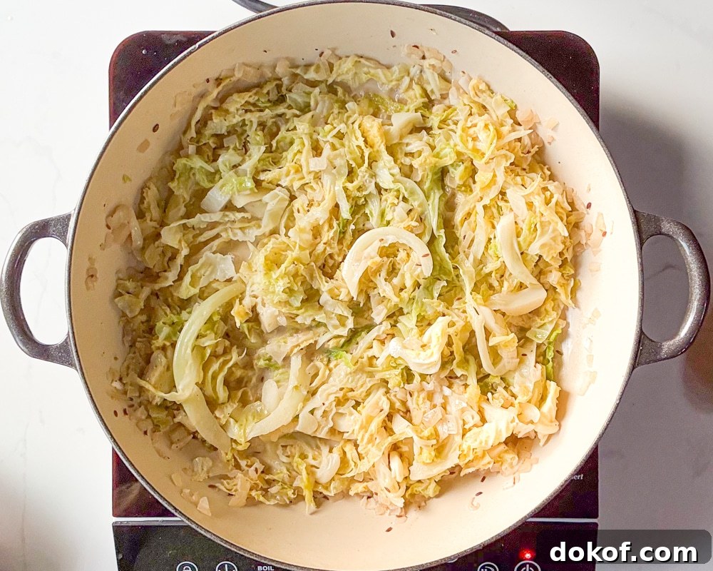 A braiser of freshly cooked French Braised Cabbage on top of an induction stovetop.