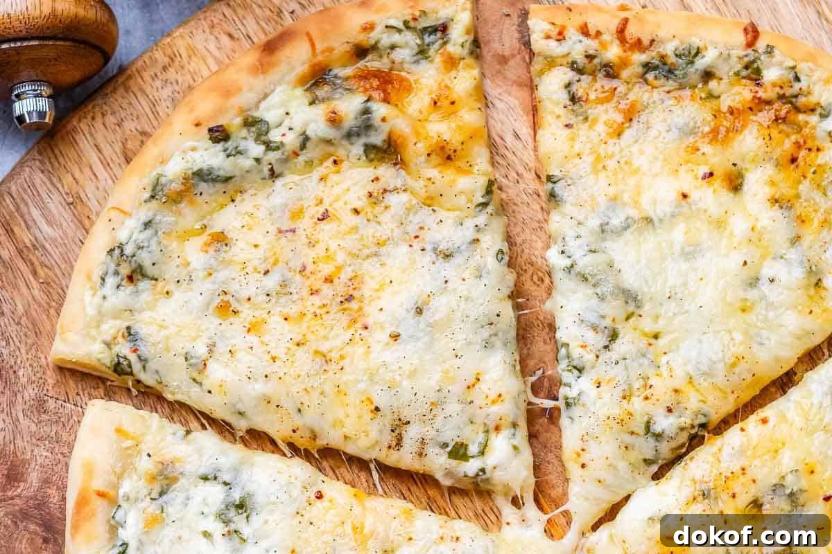 High-Protein White Pizza Recipe for Muscle Building 7 sliced white pizza on a cutting board.