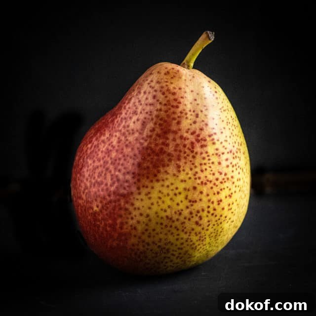 A perfect, ripe pear on a black background