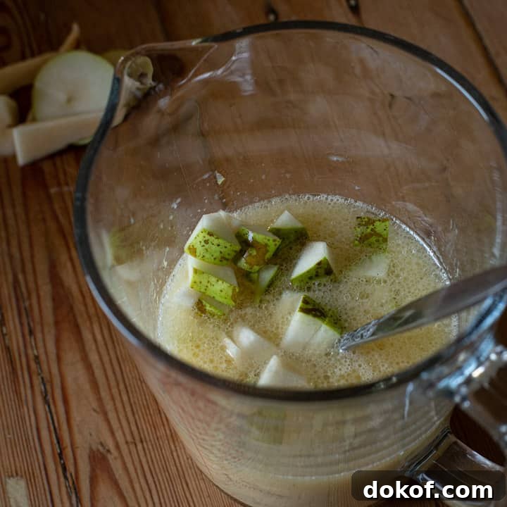 an inside shot of a jug of milk, egg and chopped pear to make spiced pear muffins