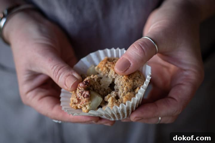 womans hands showing the moist inside of a spiced pear muffin