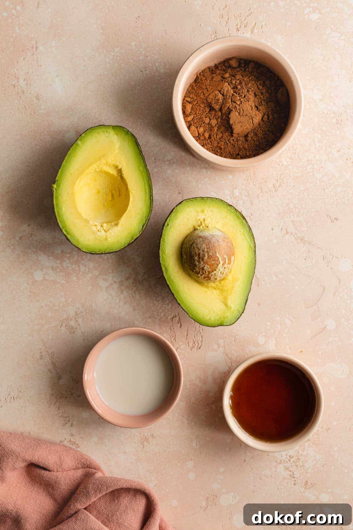 Ingredients to make chocolate avocado frosting arranged individually.