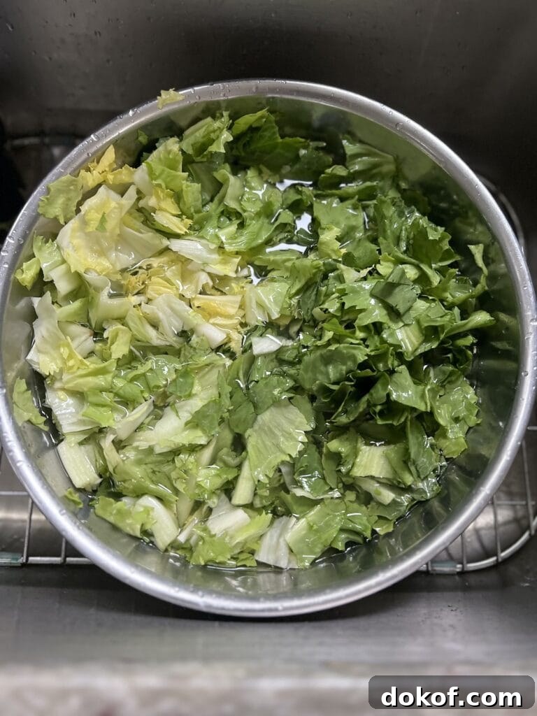 Rinsing greens in bowl with cold water.