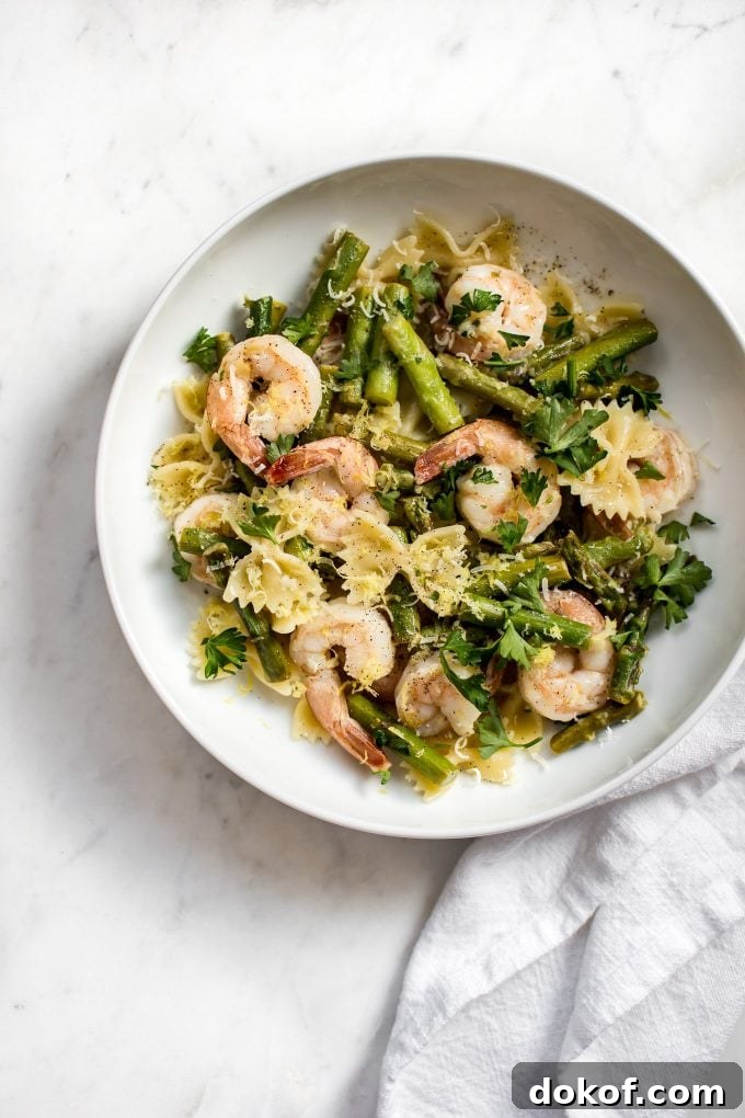shrimp asparagus pasta on a white plate