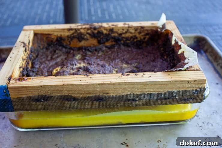 Yellow beeswax in a glass dish with a wooden screen over dish.