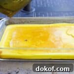 Yellow beeswax in a glass dish.