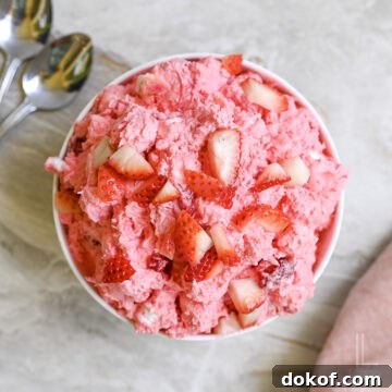 bowl of strawberry fluff salad topped with fresh strawberries.