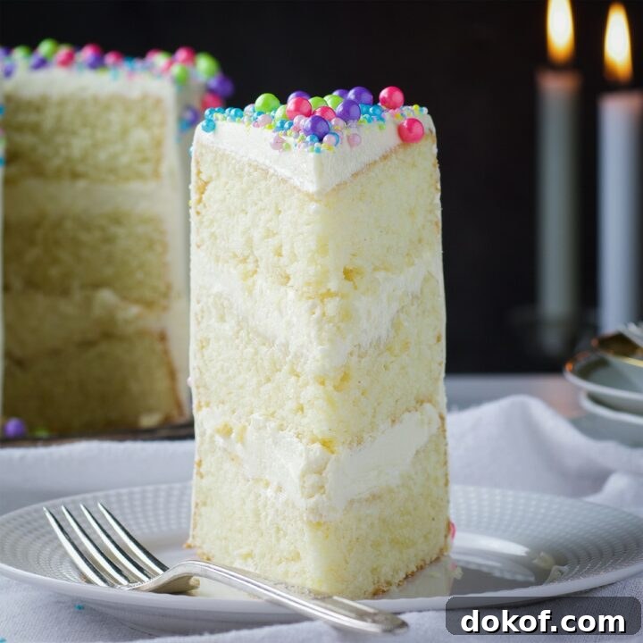 A slice of Buttercream Frosted Vanilla Layer Cake on a plate.