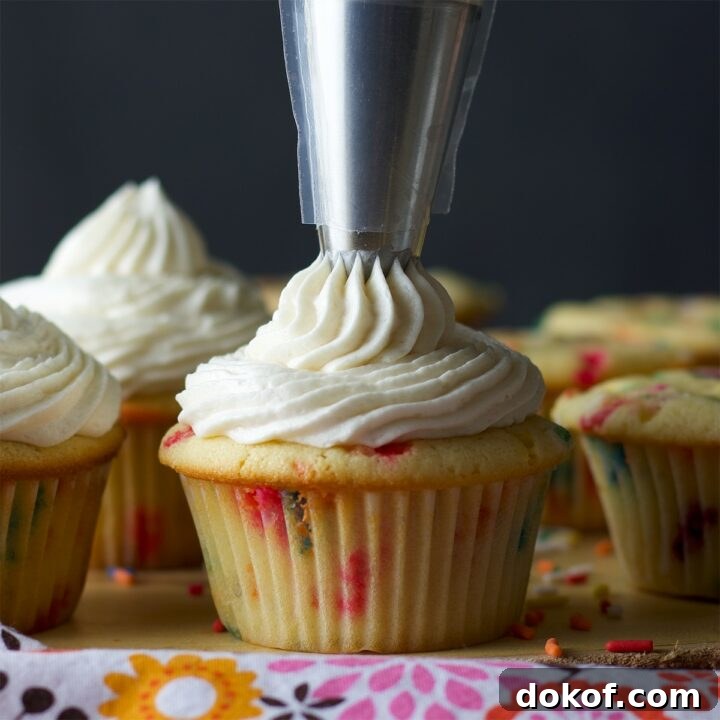 Piping American Buttercream onto Cupcakes