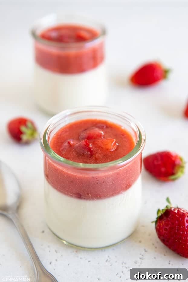 side view of a jar of coconut milk panna cotta topped with fresh strawberry puree