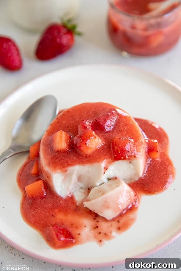 a half-eaten coconut milk panna cotta covered with homemade refined sugar-free strawberry compote 