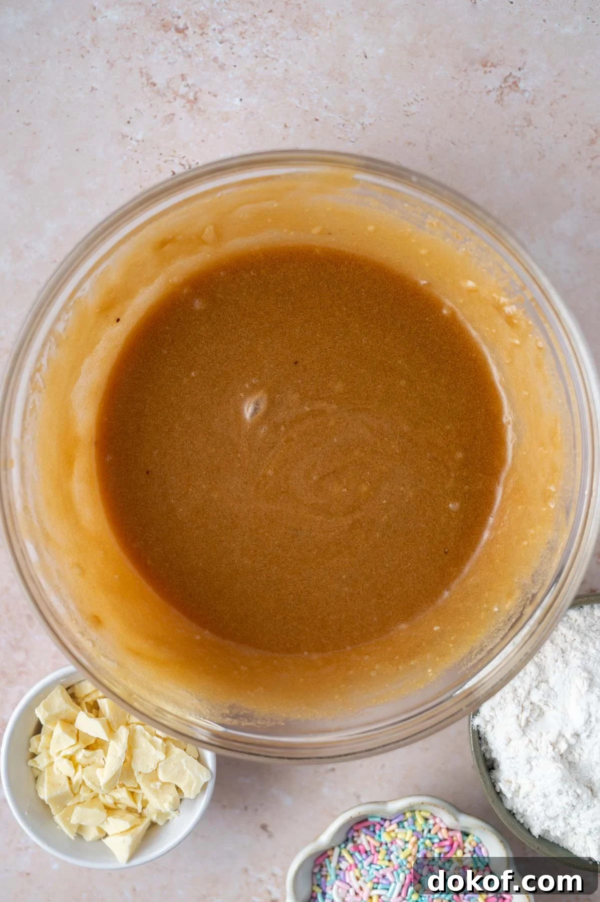 butter, sugars, eggs and extracts whisked together in a bowl