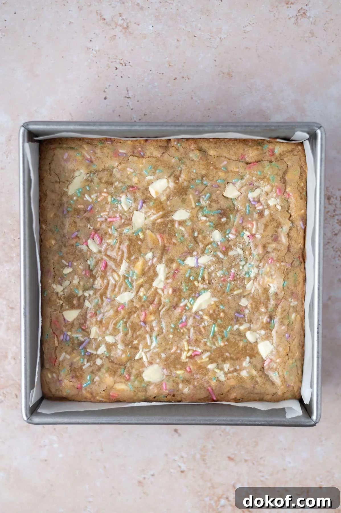 baked blondies in a parchment lined baking tin