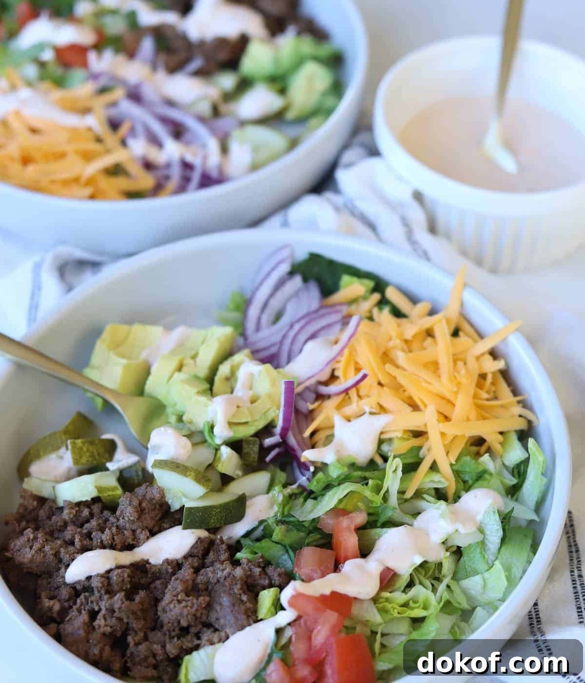 Cheeseburger bowls topped with chipotle ranch dressing. 