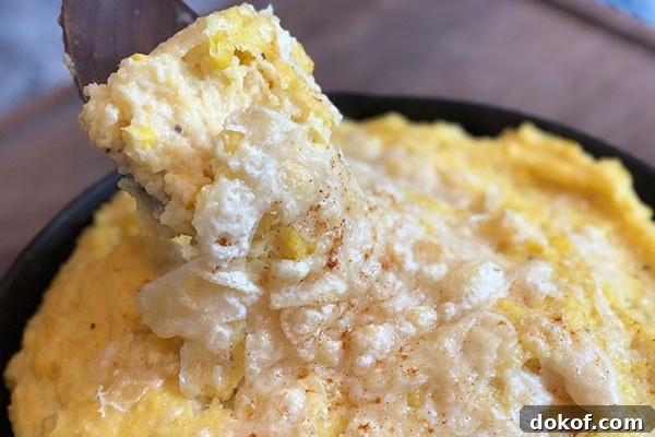 spicy sweet corn polenta with cheese on top in cast iron pan
