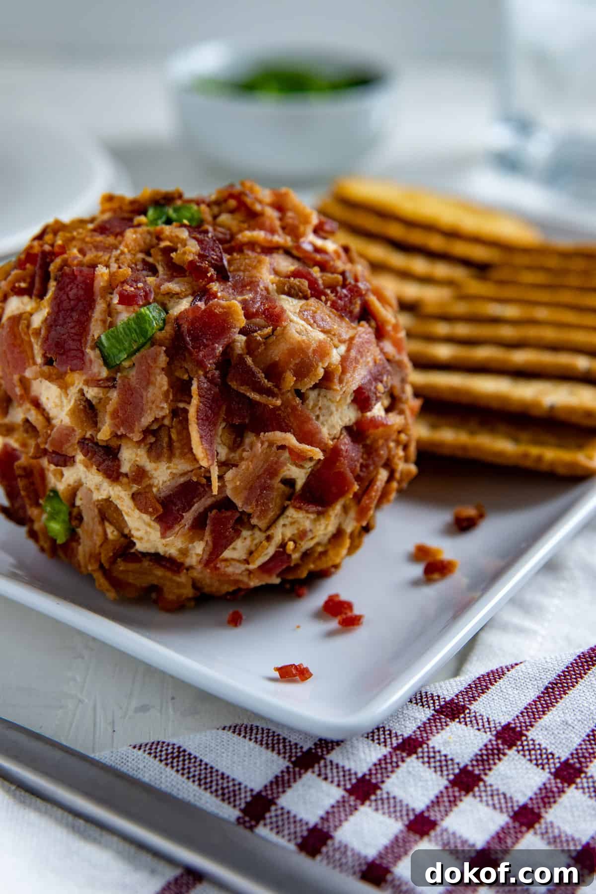 Jalapeno Cheese ball and Crackers on white rectangular serving dish.