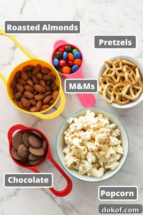 Savory Popcorn Trail Mix Recipe for Road Trips & Snacks 4 popcorn trail mix ingredients on a white marble background.