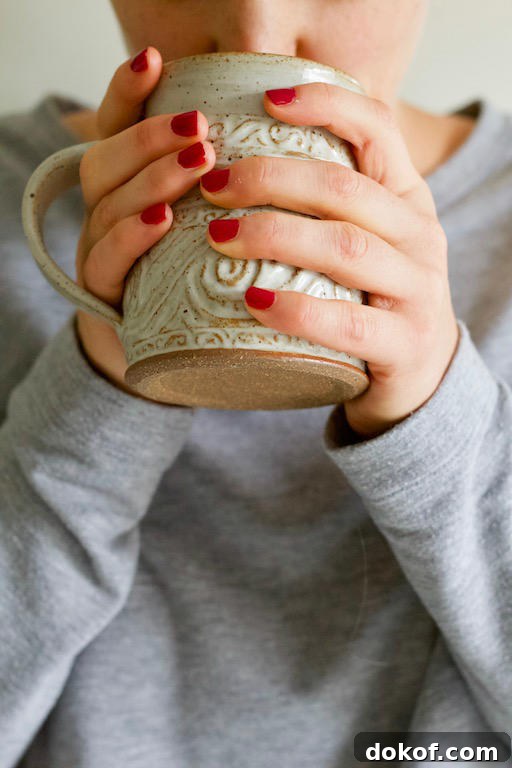 Hands Holding Cup of Pumpkin Golden Milk Recipe