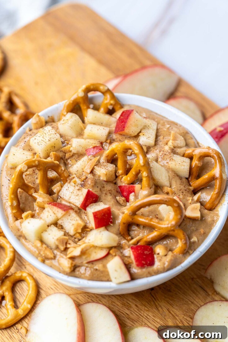 the completed caramel apple dip recipe garnished with chopped apples, peanuts, and pretzels