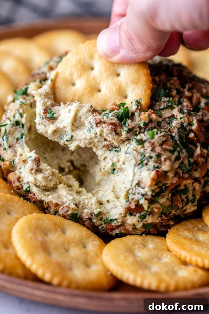 dipping into cheese ball with Ritz cracker