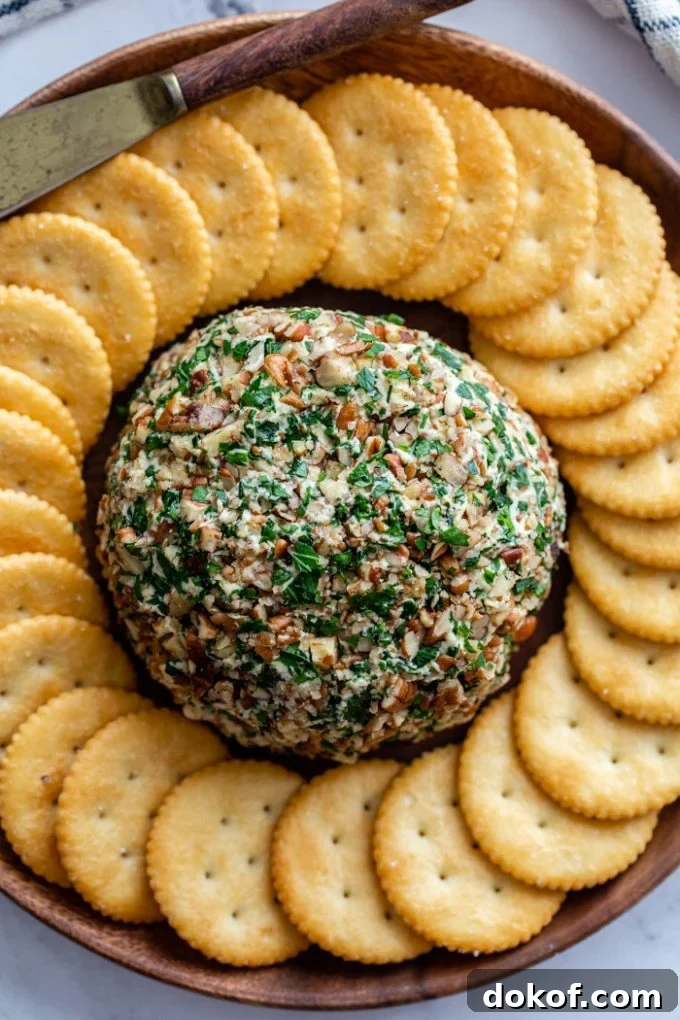 cheeseball with a ring of crackers around it on a serving plate