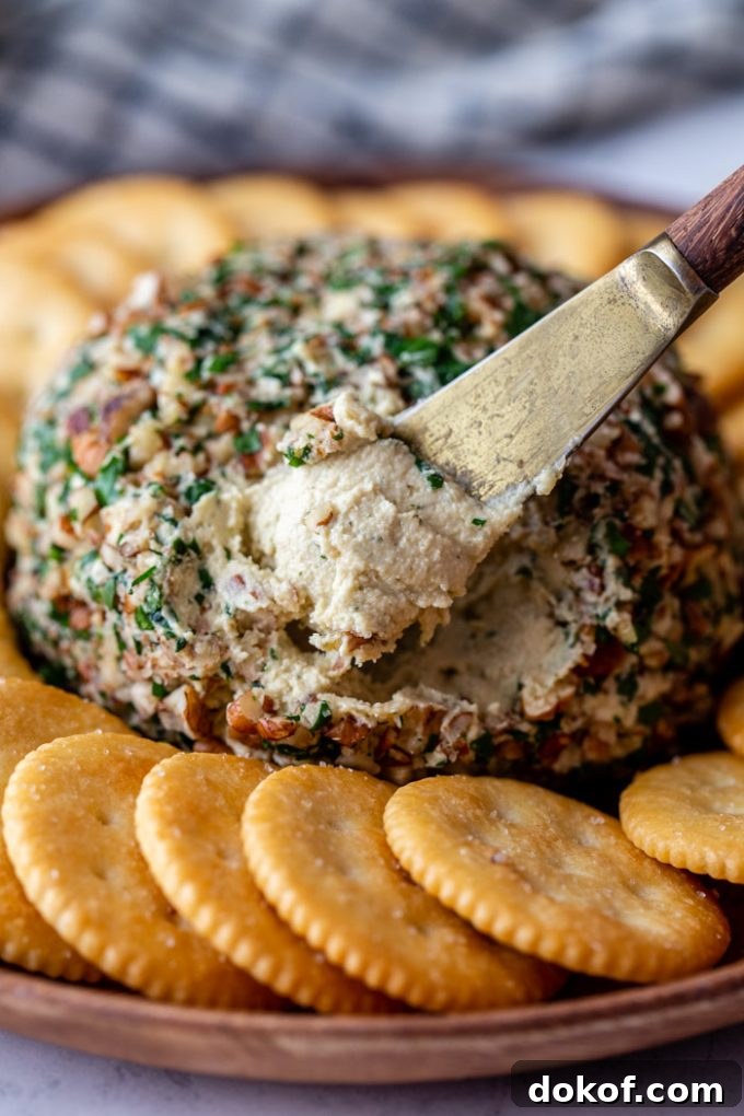 using a cheese spreader to dip into a cheeseball