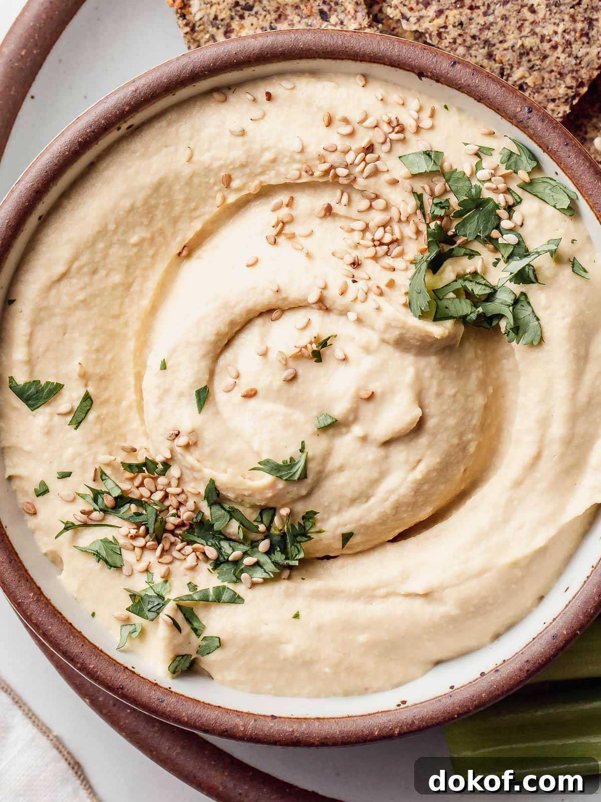 Oil free hummus in a bowl with sesame seeds on top.