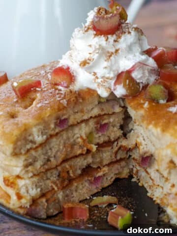 4 stacked rhubarb pancakes with piece cut out of middle