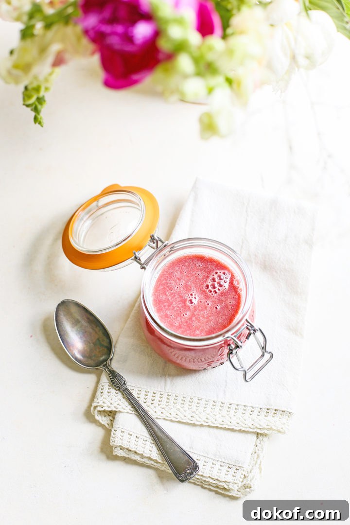 photo of a jar of raspberry curd with a spoon