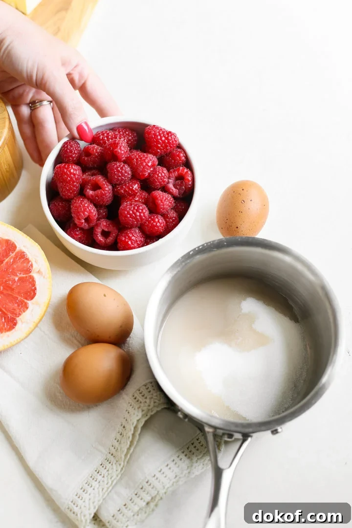 saucepan with sugar and grapefruit juice, woman picking up a bowl of fresh raspberries to make raspberry curd
