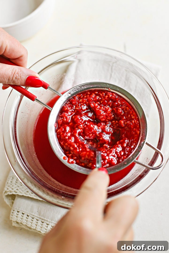 woman straining raspberries for raspberry curd recipe