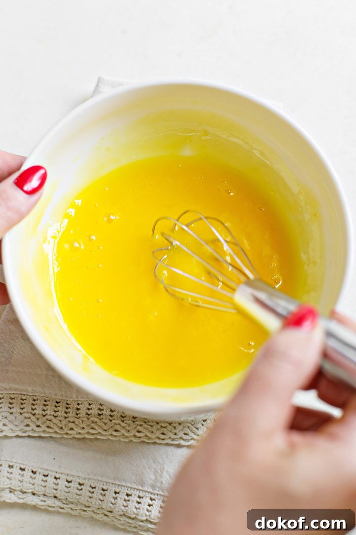 woman whisking egg yolks to make recipe for raspberry curd