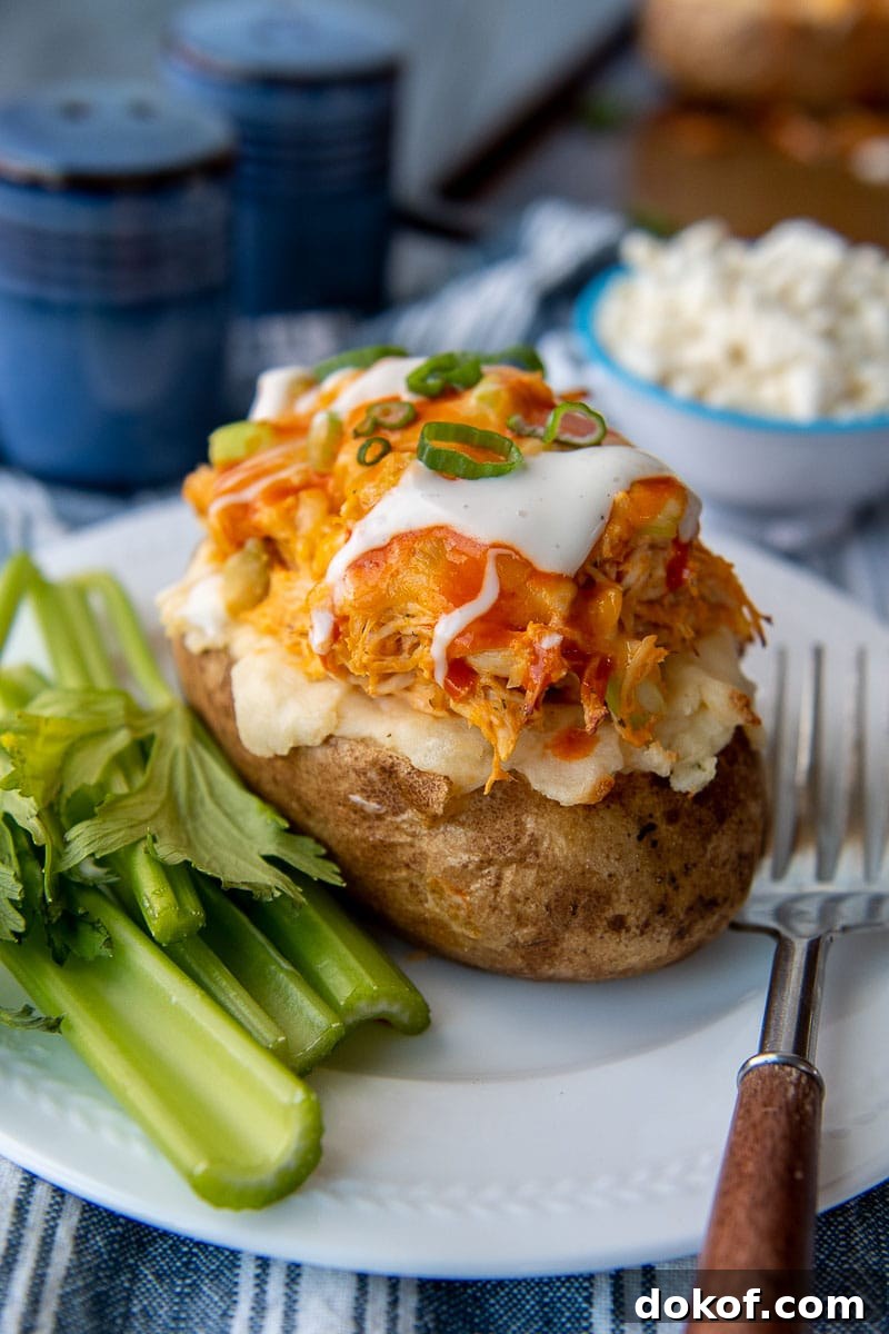 a white plate with celery and a buffalo chicken potato