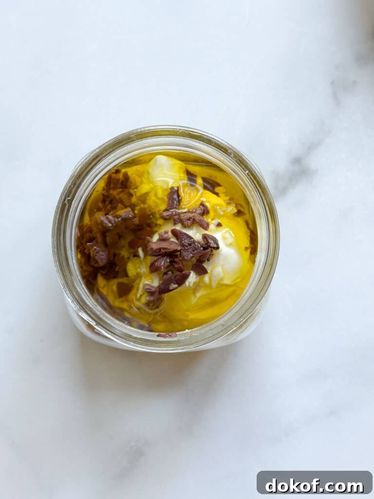 A mason jar with ingredients for Caesar dressing without anchovies.