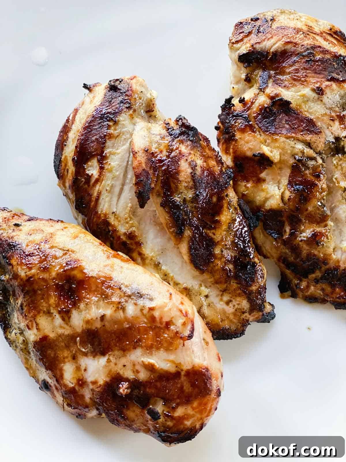 Grilled chicken breasts on a white plate.
