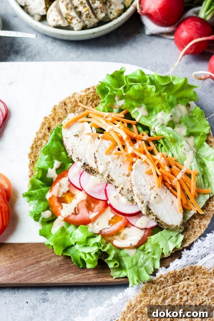 Chicken Caesar Wrap Recipe: Quick Protein-Packed Lunch 5 Greens, carrots, raddish, tomatoes and chicken with caesar dressing on a wrap.