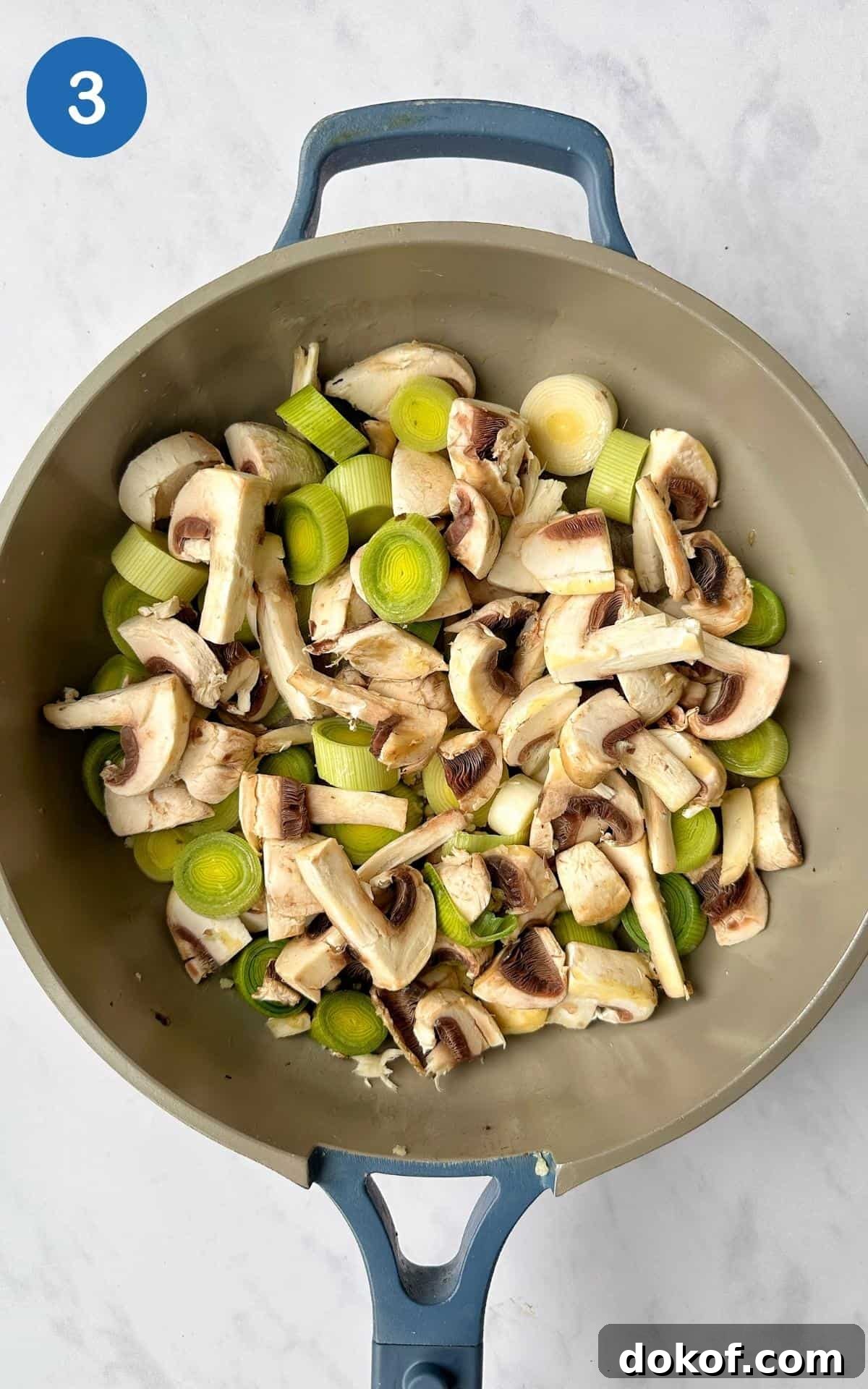 Chopped leeks and mushrooms frying in a non-stick frying pan.