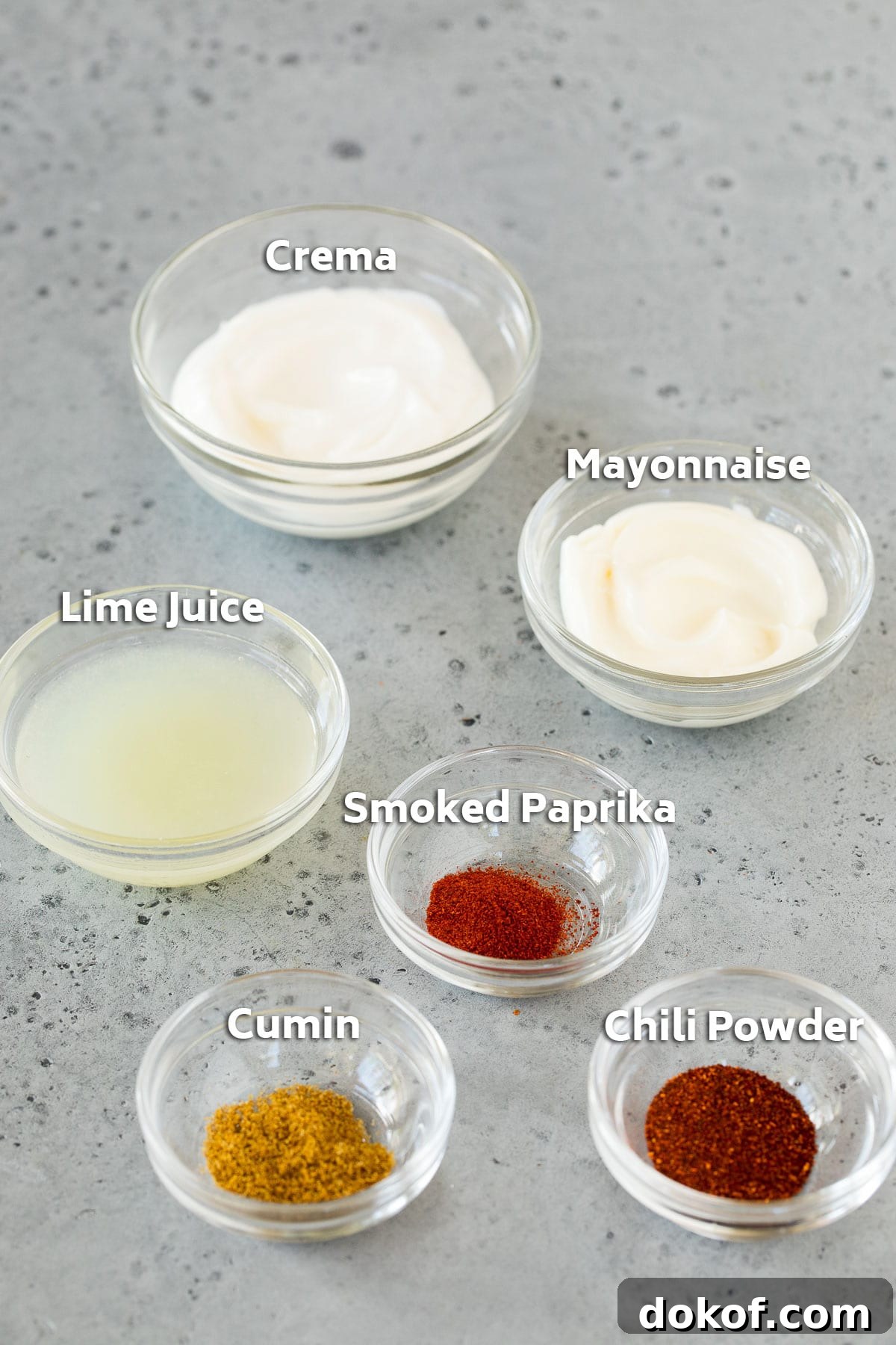 Bowls of dressing ingredients including mayonnaise, cream and spices.