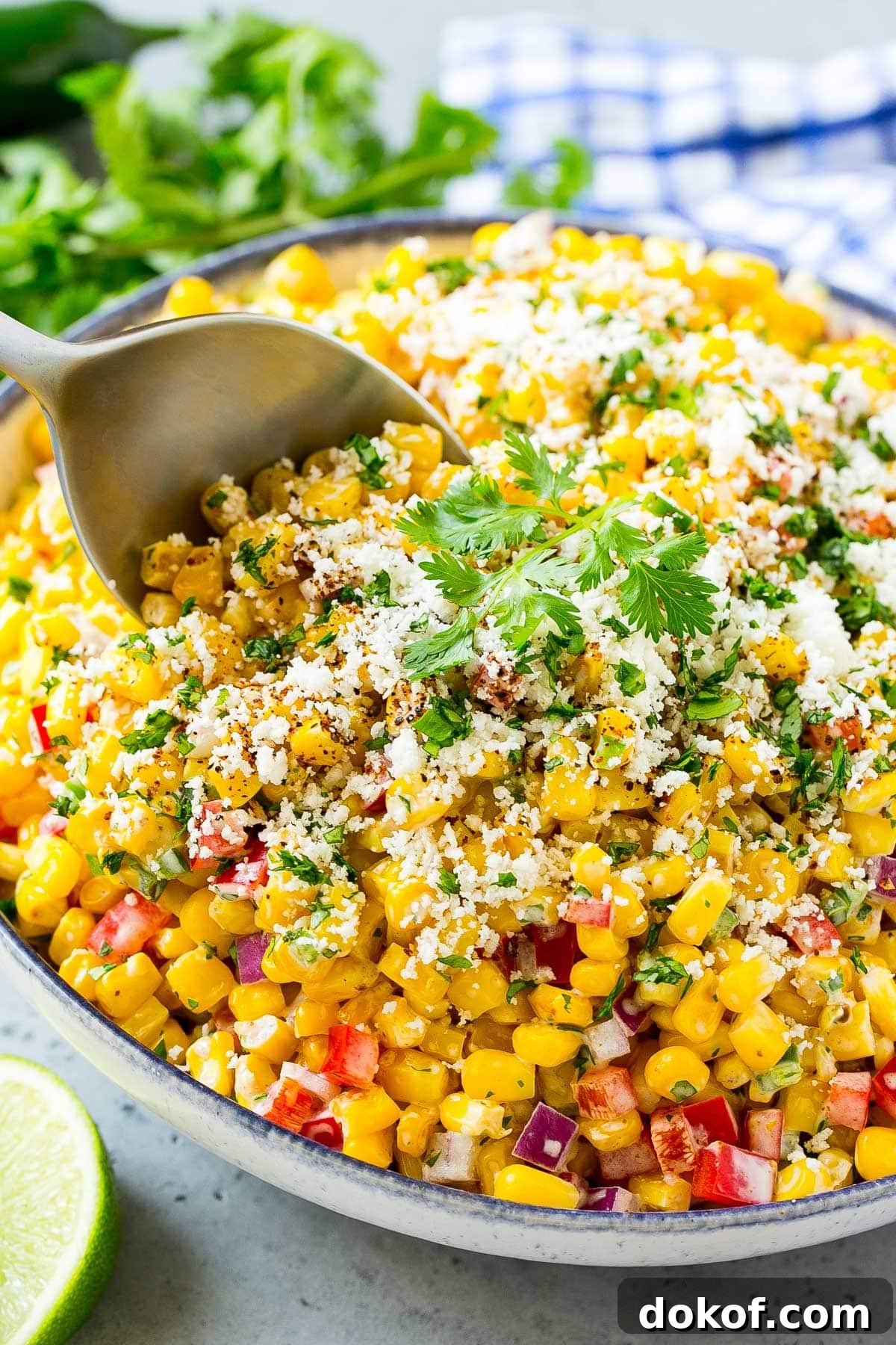 A serving spoon in a bowl of Mexican corn salad.