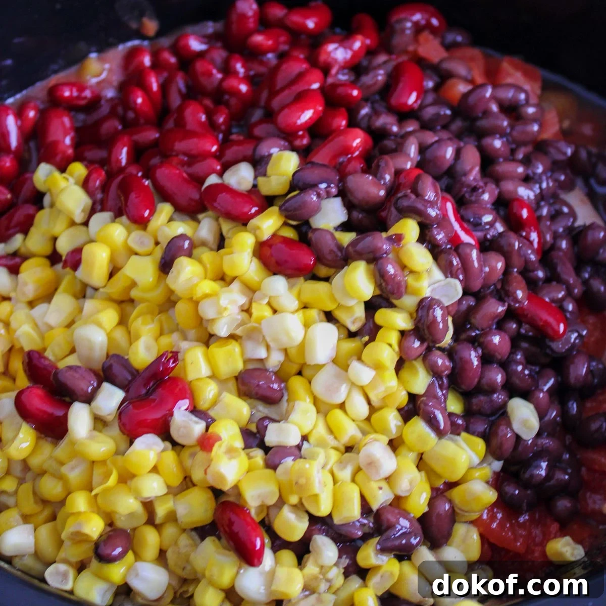 Added black beans, kidney beans, and corn to the slow cooker. 