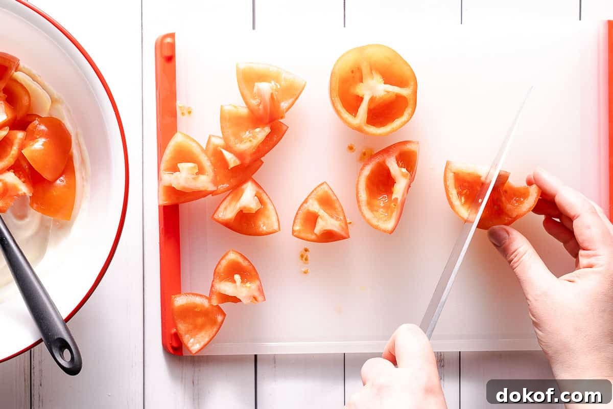 cutting tomatoes on cutting board with bowl on the side