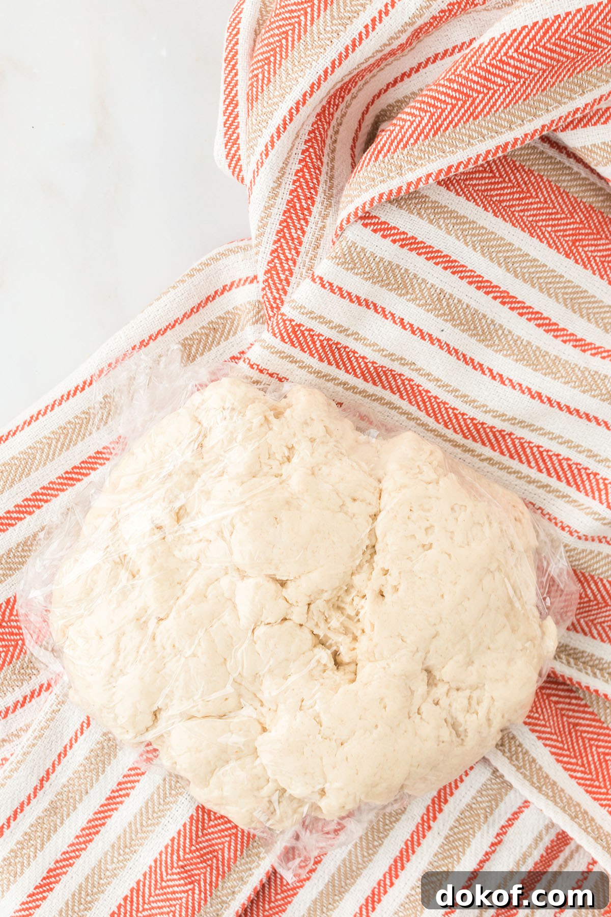 Sopapilla dough in plastic wrap.