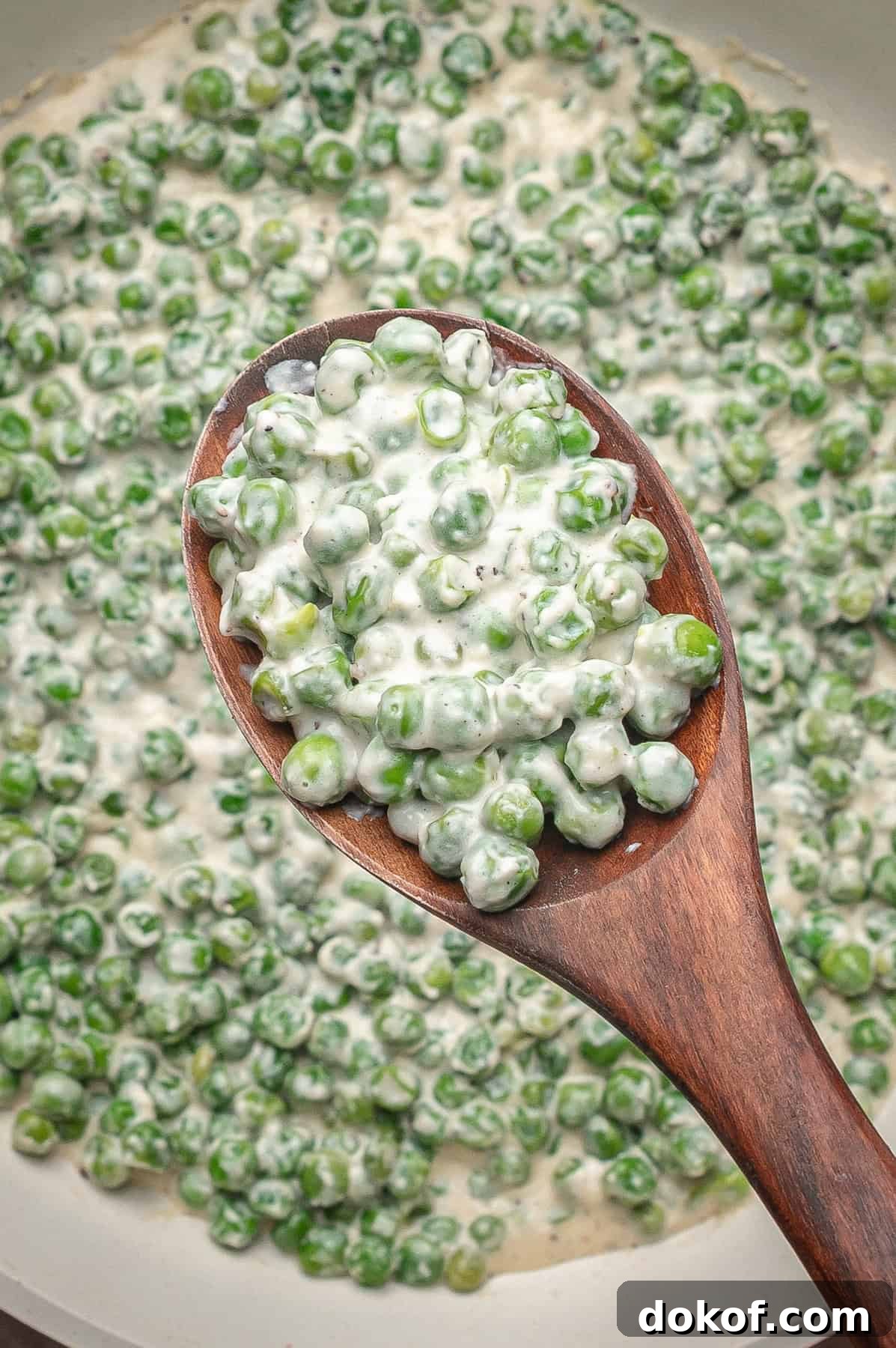 Creamed peas on a wooden spoon