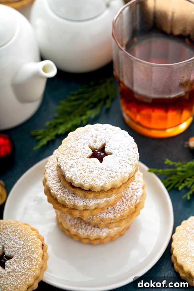 Classic Linzer Cookies Recipe: How to Make Austrian Jam Sandwich Cookies 3 Linzer cookies stack on a white plate