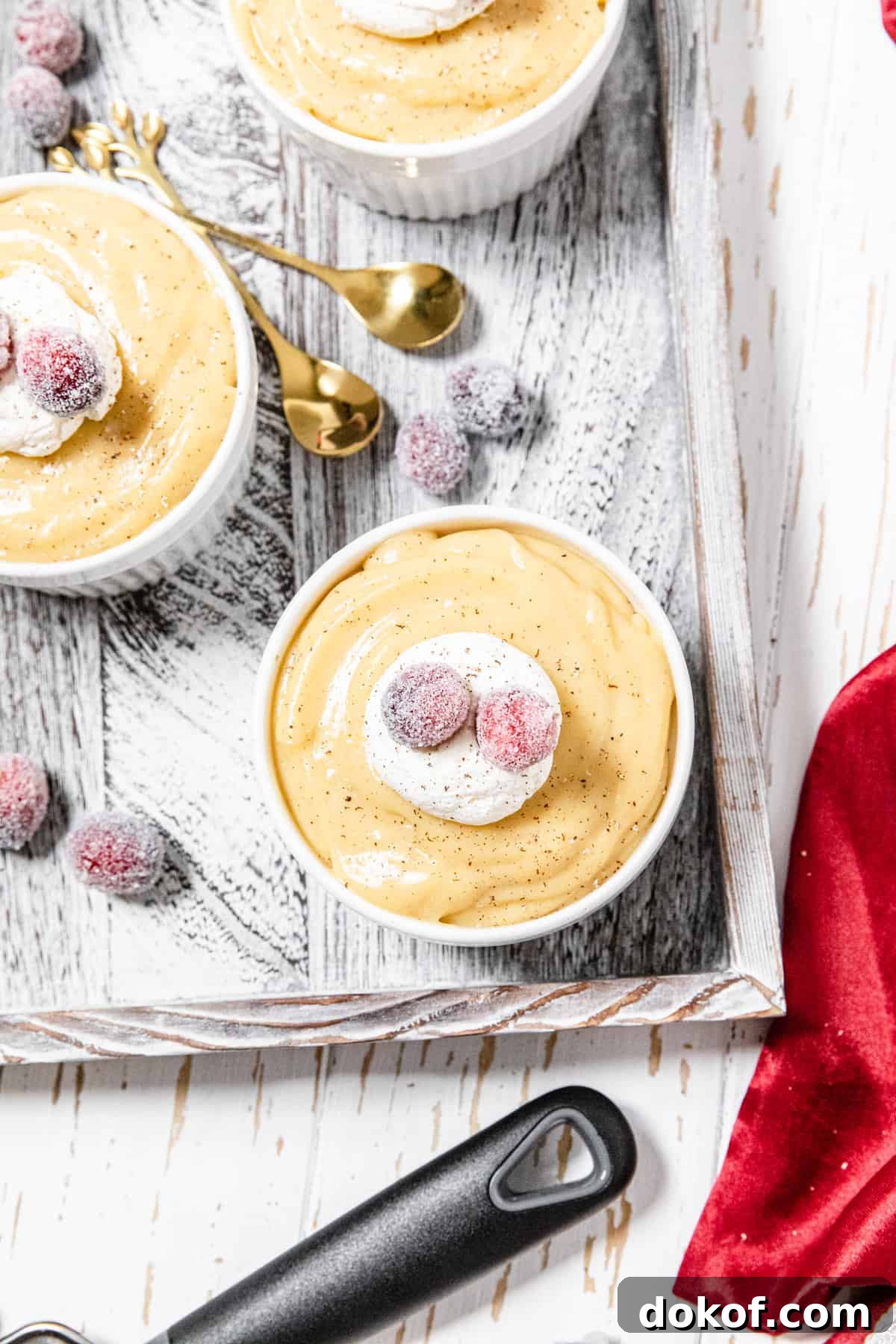 Creamy Homemade Eggnog Pudding Recipe for the Holidays 3 top view of three pudding filled ramekins topped with sugared cranberries