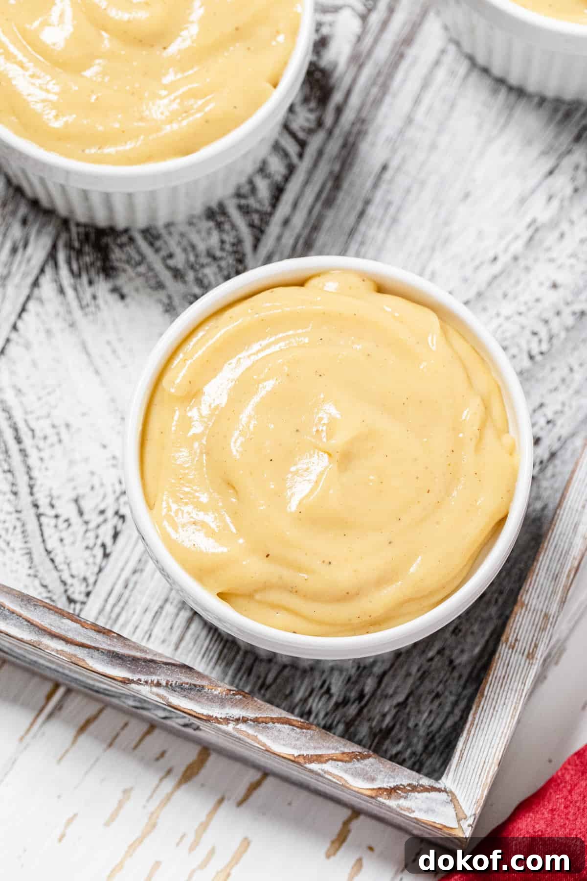 Creamy Homemade Eggnog Pudding Recipe for the Holidays 5 top view close up of plain pudding in a white ramekin in a wooden tray