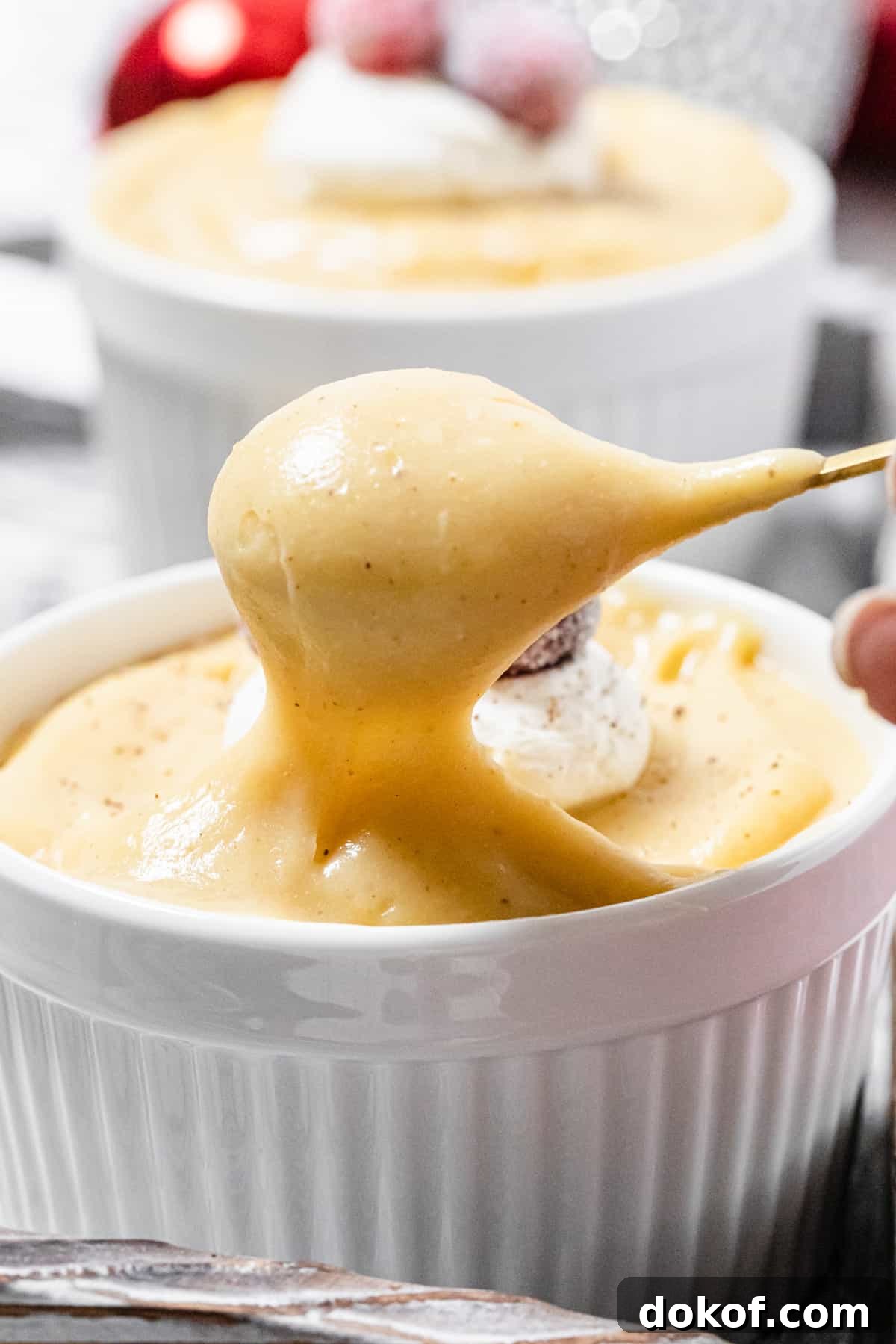 Creamy Homemade Eggnog Pudding Recipe for the Holidays 8 taking a spoonful of pudding out of ramekin