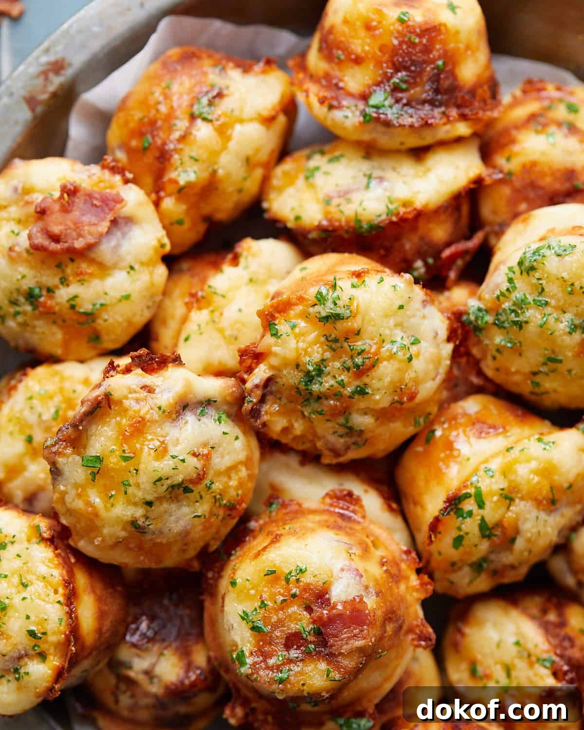 Overhead image of bacon and cheddar cheese muffins with garnish.