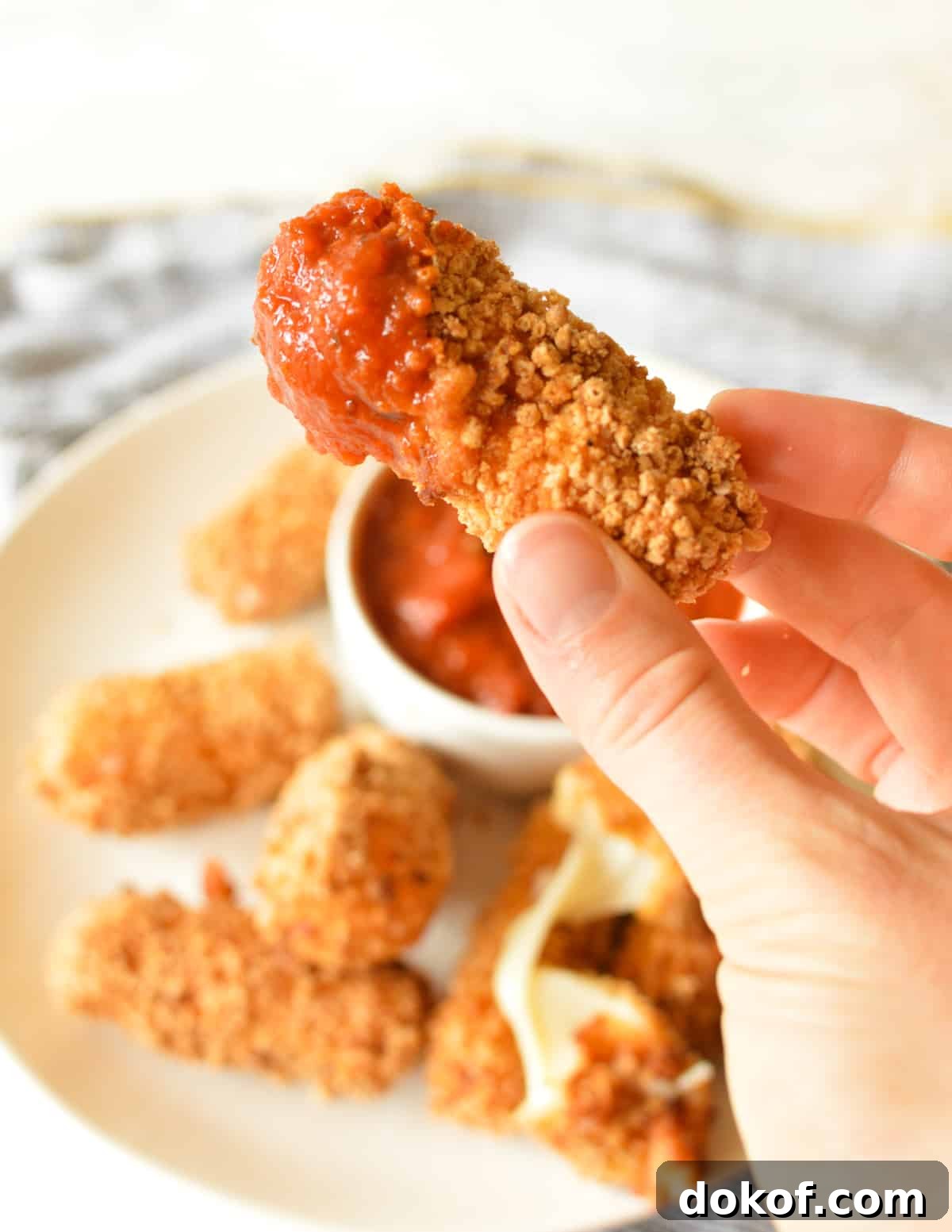 a mozzarella stick dipped in marinara